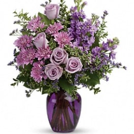 Purple and lavender bouquet in a purple glass vase