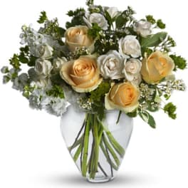 Cream and white roses arranged in a clear glass vase