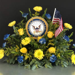 Yellow and blue floral tribute with a U.S. Navy emblem and American flag