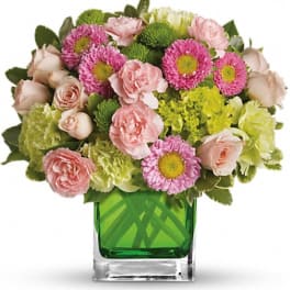 Pink and green mixed bouquet in a square glass vase