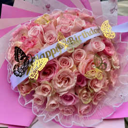 Pink rose bouquet with a birthday ribbon and butterfly decorations