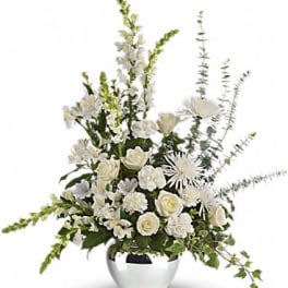 Tall white floral arrangement with roses, carnations, and spider mums in a round silver vase