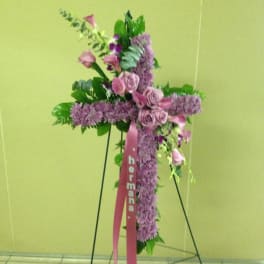 Pink and purple floral cross on a stand with ribbon