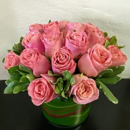 Pink roses arranged in a green round vase