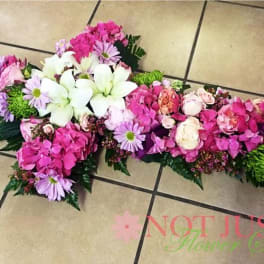Pink and white floral casket spray with lilies and daisies