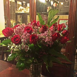 Red roses and pink filler flowers in a clear glass vase