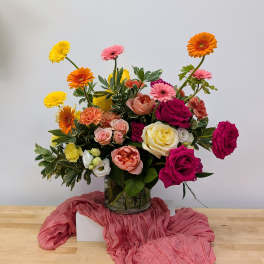 Mixed bouquet of roses and gerbera daisies in a glass vase