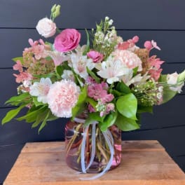 Pink and white mixed flower arrangement in a glass vase