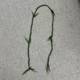 Braided green floral garland on a gray surface