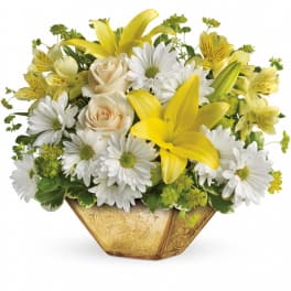 Yellow lilies and white daisies with cream roses in a gold vase