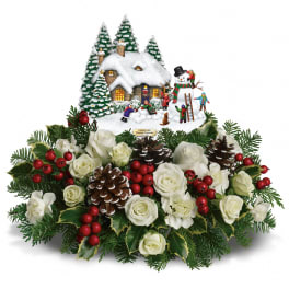 Christmas arrangement with white roses and a snowy village scene