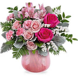 Pink rose and carnation bouquet in a pink glass vase
