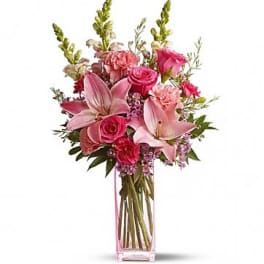 Pink bouquet with lilies and roses in a clear rectangular vase