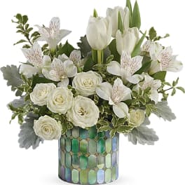 White tulips and roses arranged in a mosaic glass vase
