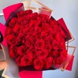 Large bouquet of red roses wrapped in pink and burgundy paper