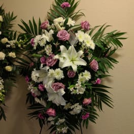 Standing floral spray with white lilies, pink roses, and white daisies
