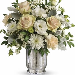 Cream roses and white blooms in a clear glass vase