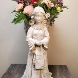 Flower arrangement in a statue vase with pink, yellow, and purple blooms