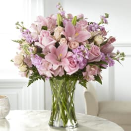 Pink bouquet of lilies and roses in a clear glass vase