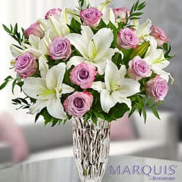 Pink roses and white lilies arranged in a clear glass vase