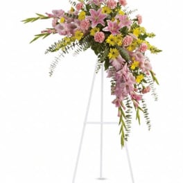 Pink and yellow floral spray on a white easel stand