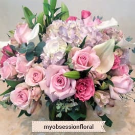 Pink roses and white calla lilies arranged with pale hydrangeas