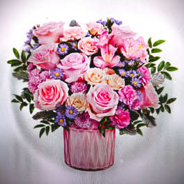 Pink and cream rose arrangement with lavender filler flowers in a pink glass vase