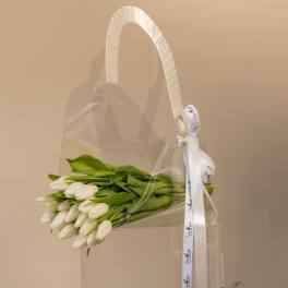White tulips in a clear tote with a white ribbon handle