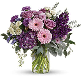 Purple and pink mixed bouquet in a clear glass vase