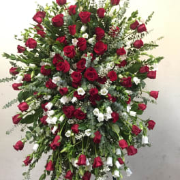Large standing spray of red roses and white flowers on an easel