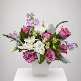 Pink and white mixed flower arrangement in a square white vase