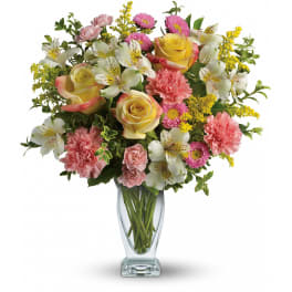 Mixed bouquet of roses, carnations, and white alstroemeria in a glass vase
