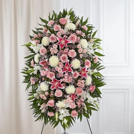 Standing floral spray with pink roses, white lilies, and red lilies