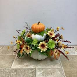Pumpkin centerpiece with yellow flowers in stacked white containers