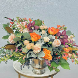 Mixed bouquet in a silver vase with orange and blush flowers