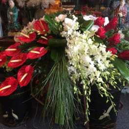 Large floral arrangement with red anthuriums and white orchids in black containers