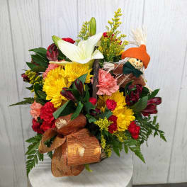 Mixed bouquet with yellow and red flowers and a small scarecrow decoration