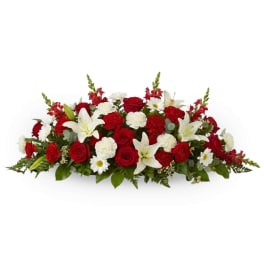 Low floral arrangement with red roses, white lilies, and white daisies