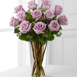 Lavender roses arranged in a clear glass vase