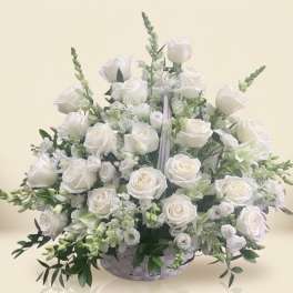 White rose arrangement in a low white basket