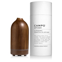 Wood-grain ultrasonic diffuser beside a white cylindrical box