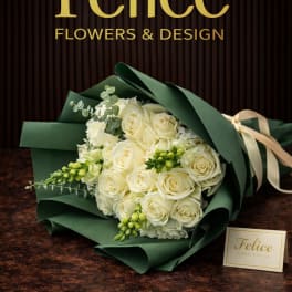 Bouquet of cream roses wrapped in dark green paper
