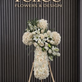 White floral standing cross on an easel