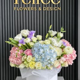 Pastel flower arrangement in a white hat box with hydrangeas and roses