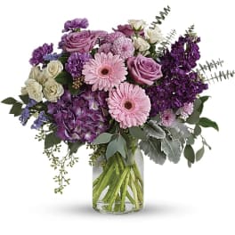 Bouquet of pink and purple flowers in a clear glass vase