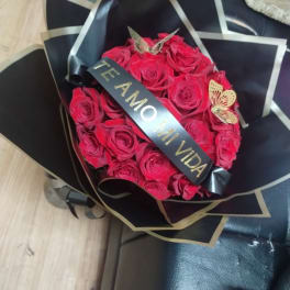 Bouquet of red roses wrapped in black paper with a ribbon