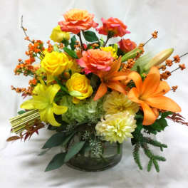 Colorful bouquet of roses and lilies in a glass vase