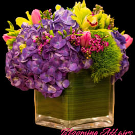 Purple hydrangeas and pink tulips in a square glass vase