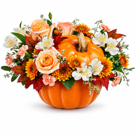 Pumpkin centerpiece with peach roses, white alstroemeria, and orange mums