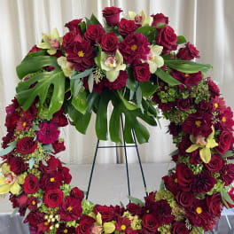 Heart-shaped floral wreath with red roses and burgundy blooms